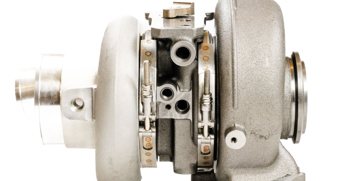Side view of a diesel turbocharger, showing the compressor and turbine housings with the center cartridge assembly.