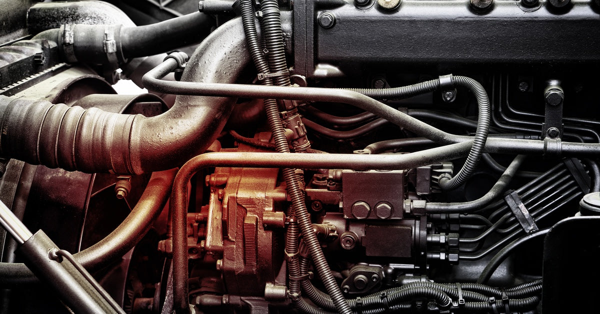 A diesel truck engine showing the turbocharger, fuel system components, and engine piping beneath the valve cover.