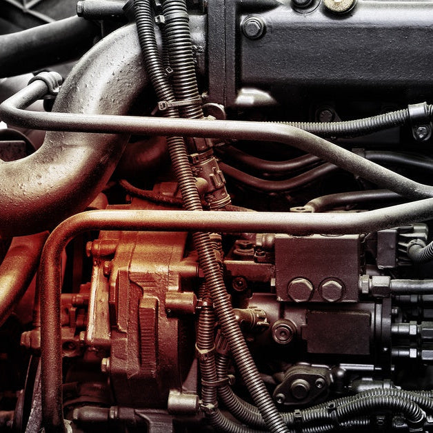 A diesel truck engine showing the turbocharger, fuel system components, and engine piping beneath the valve cover.